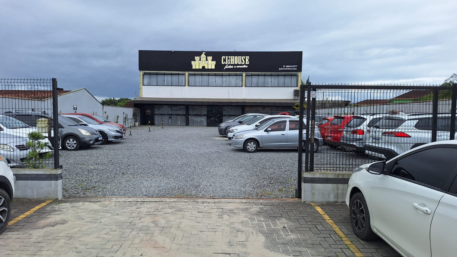 Fachada da CJ's House com estacionamento na frente